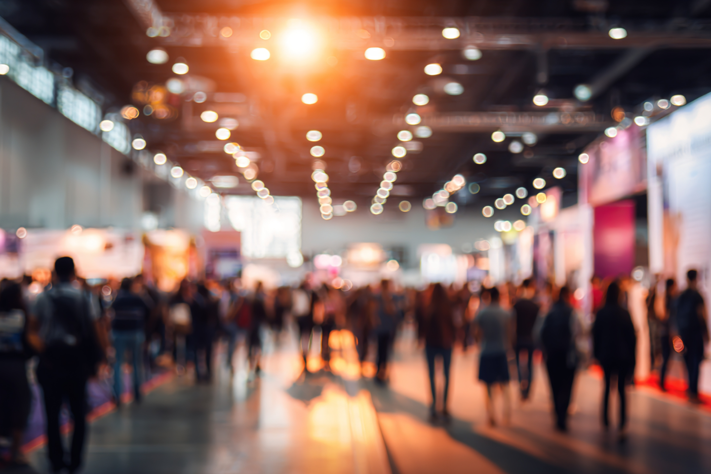 A busy exhibition hall lit with warm overhead lights